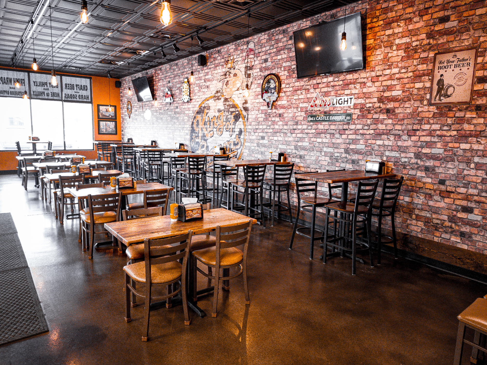 Alternate seating view showing tables, chairs, and branded wall art in the Hermantown dining area.