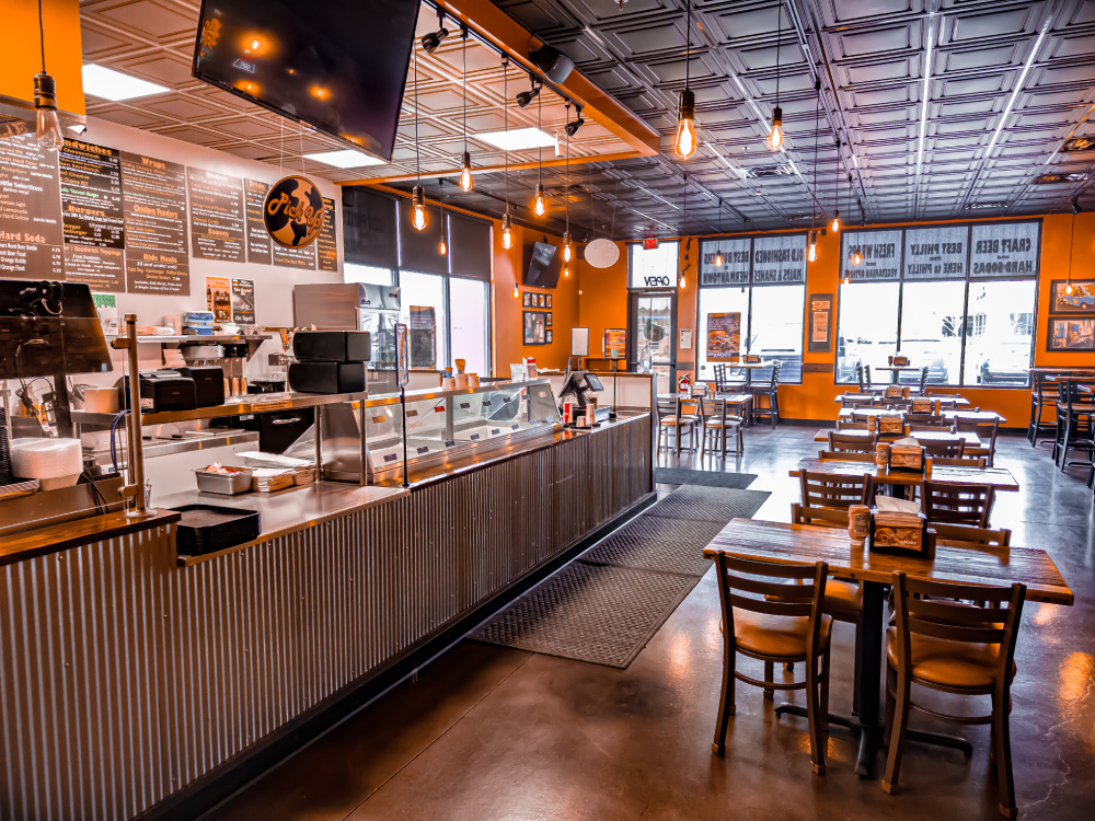 Counter area with digital menu boards, order pickup station, and visible kitchen pass-through.