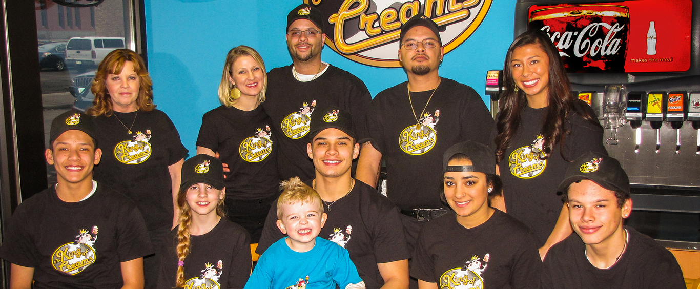 Courtland standing beside an ice cream truck, looking toward the street – symbolizing humble beginnings and community presence